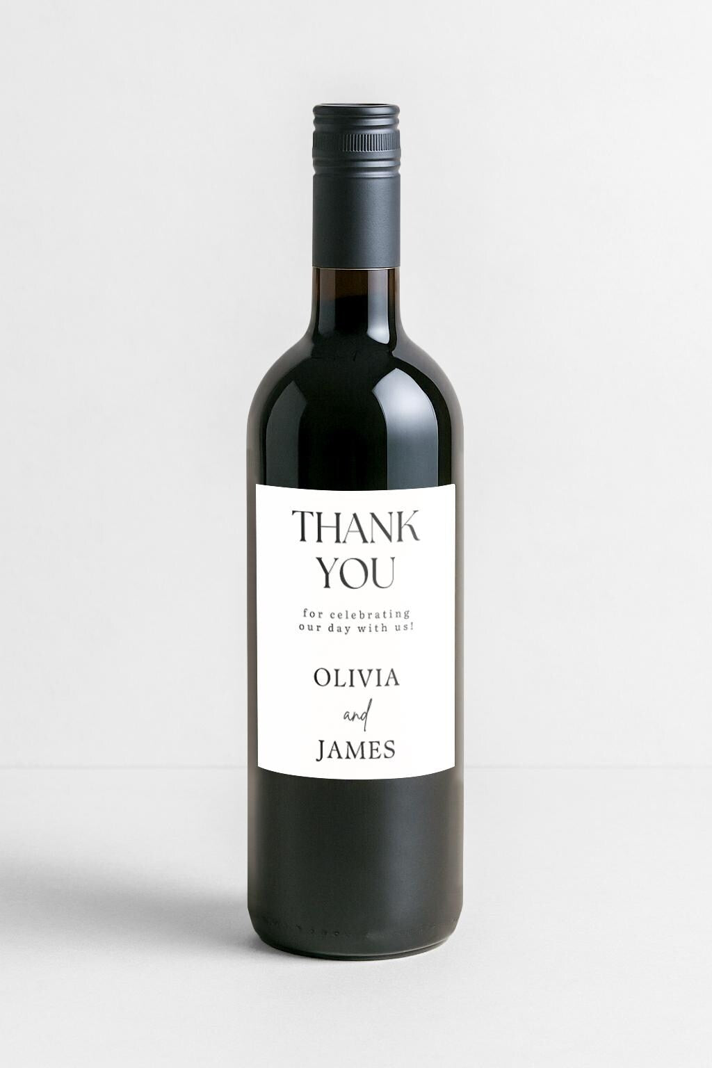 Wedding reception table with wine favour bottles featuring personalised thank you labels for guests