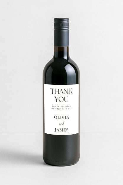 Wedding reception table with wine favour bottles featuring personalised thank you labels for guests